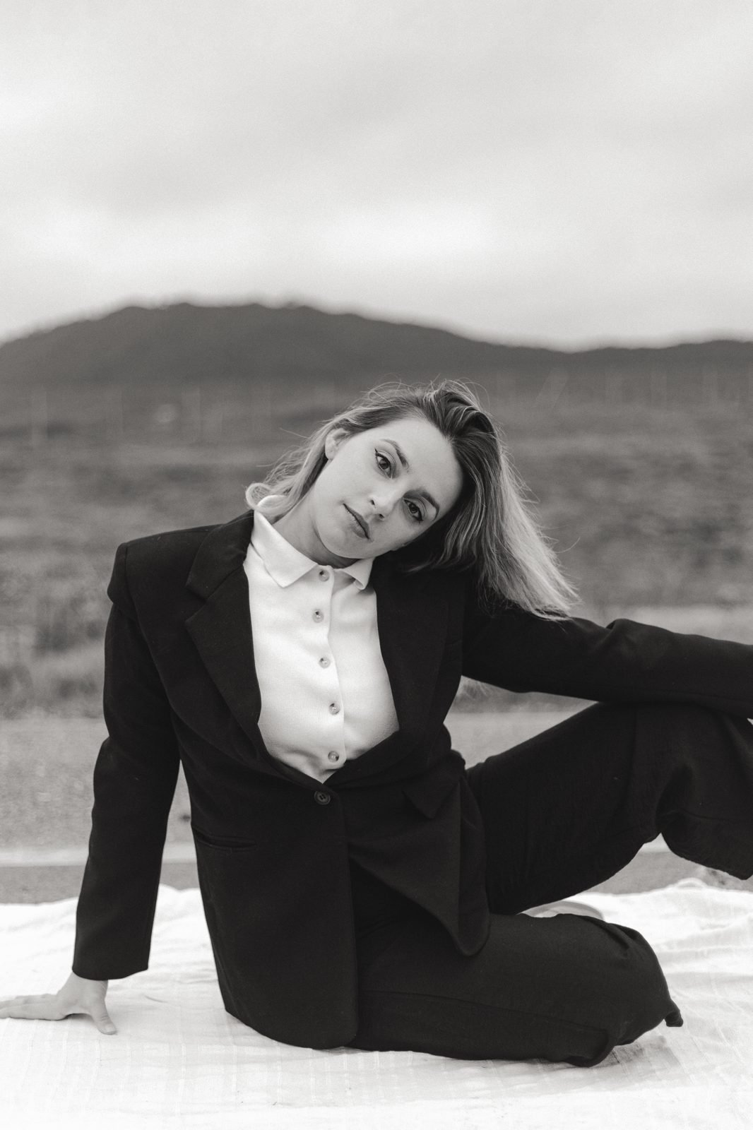 Retrat editorial en blanc i negre d'una dona amb americana davant les muntanyes